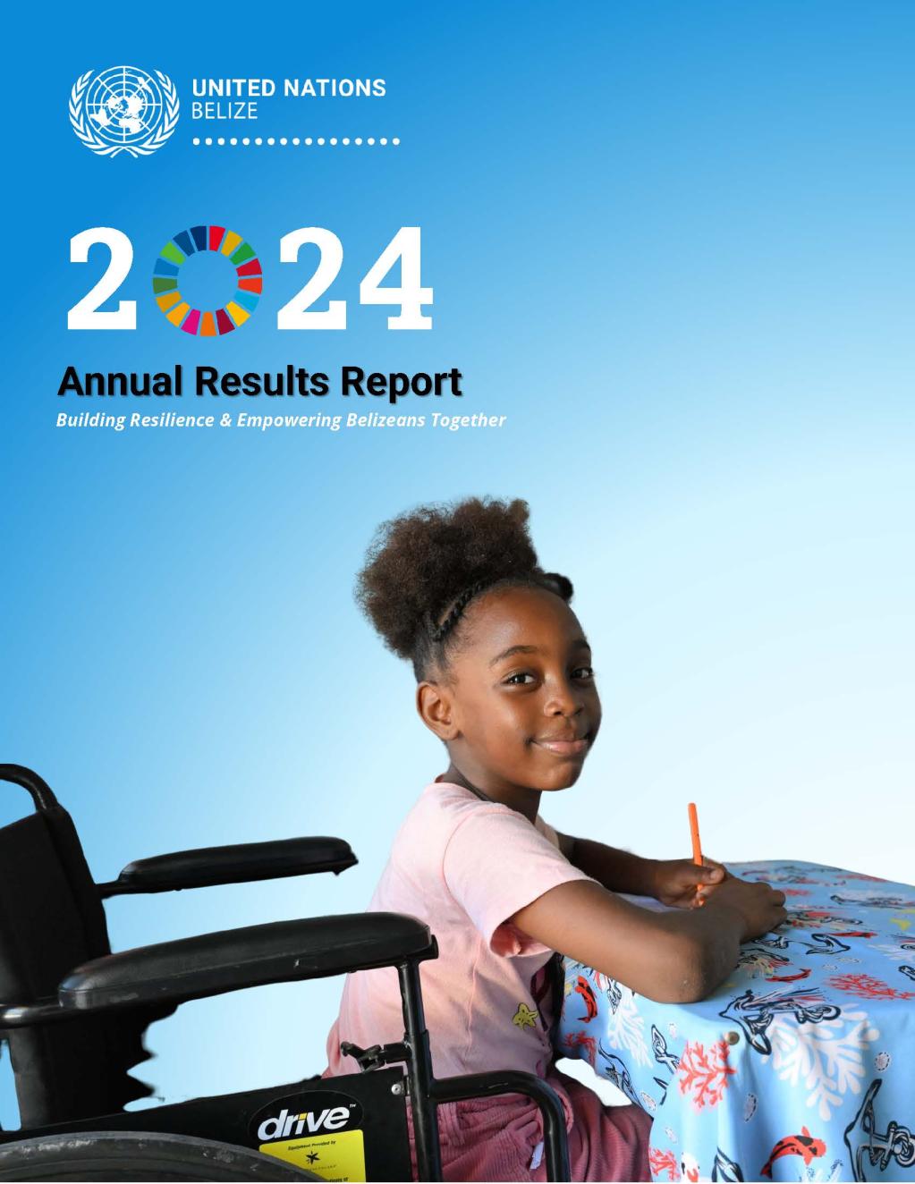 Young girl in a wheelchair sitting at a cloth covered table with a pencil in her hand