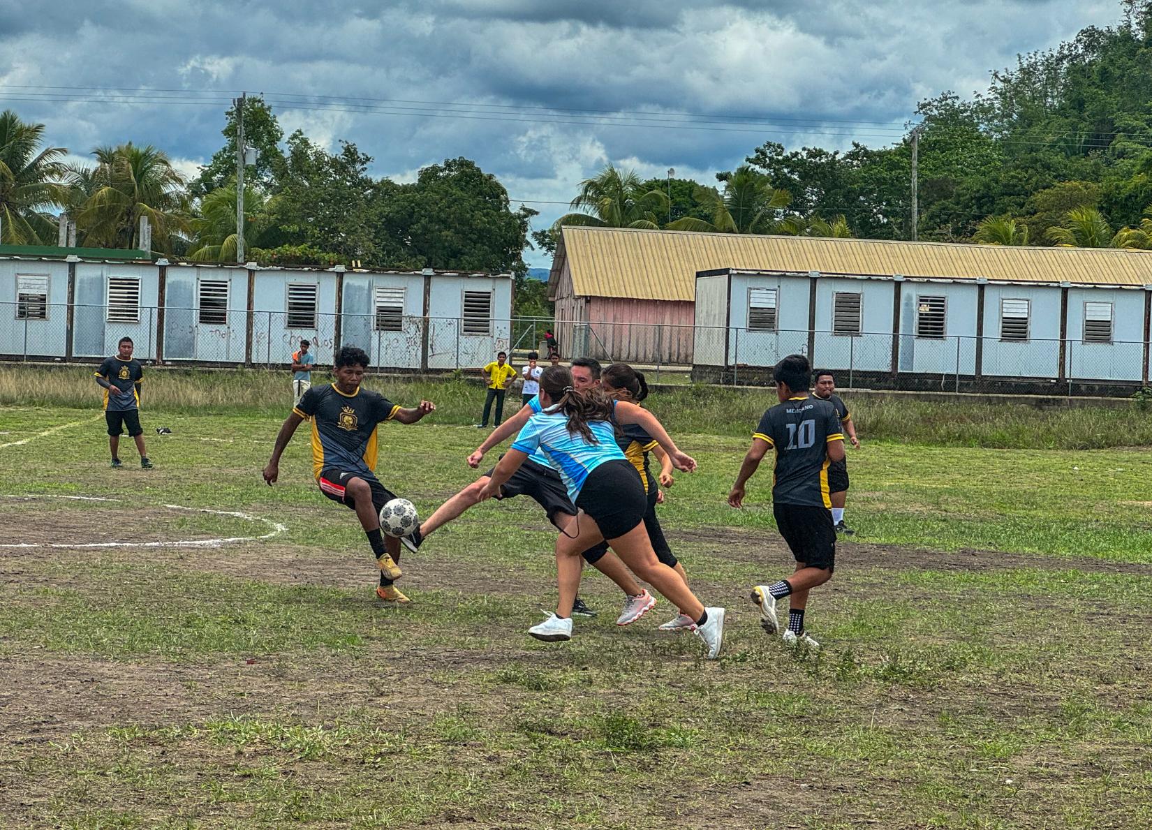 Four persons engaged in football match tackle 