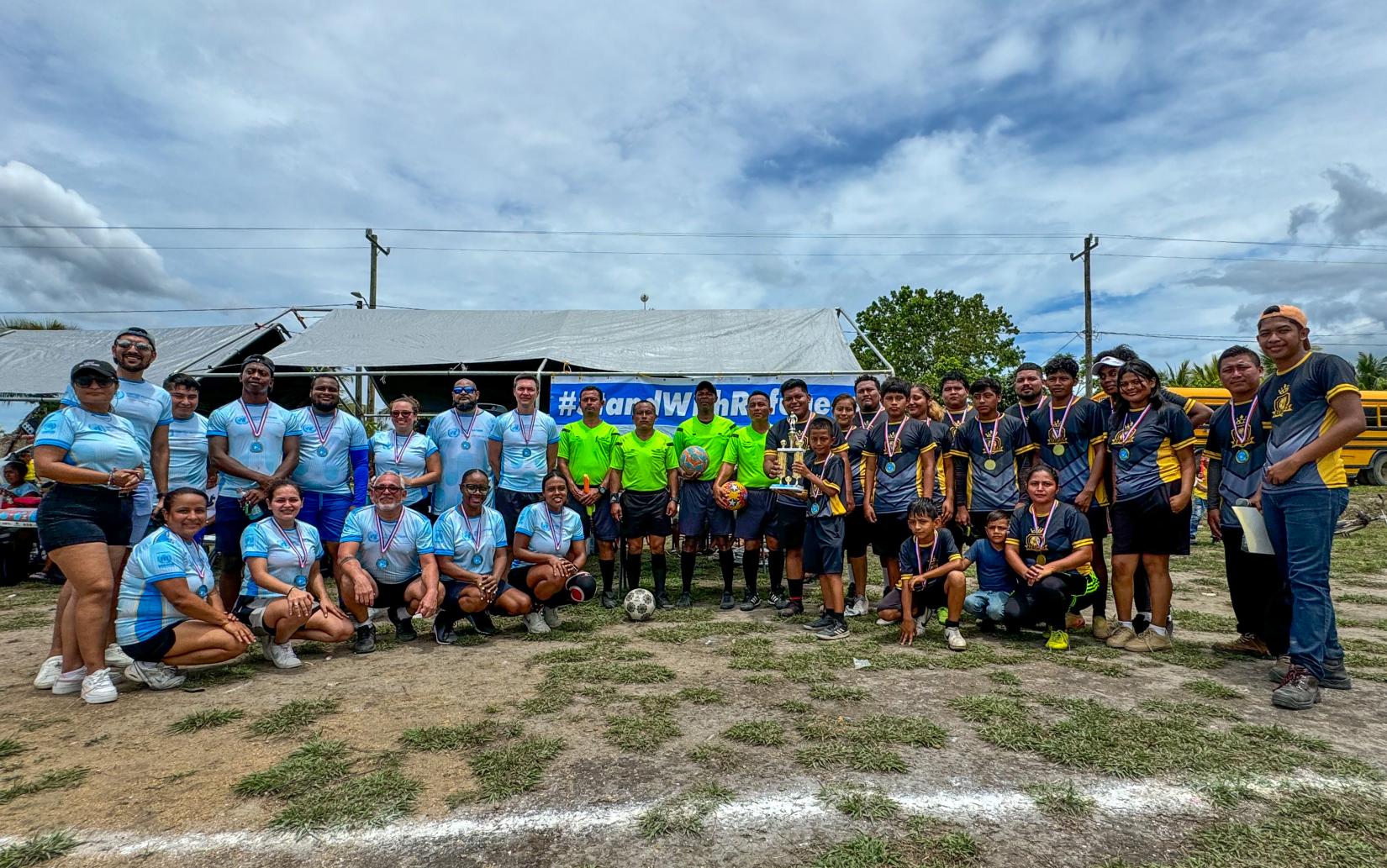 Two teams and officials stand for a group photo 